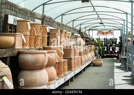 Various styles of terracotta frost proof pots and containers on display and on sale in a garden centre. Stock Photo