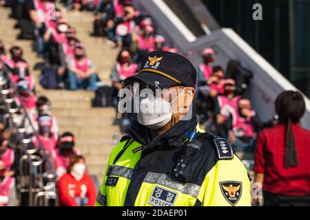 Seoul, South Korea. 12th Nov, 2020. A policeman wearing a face mask is seen in front of protesters at Seoul Railway Station during a rally.Korean Railway Workers' Union members stage a rally against KORAIL (Korea Railroad Corporation) and the government's policy in front of Seoul Regional Employment and Labor Administration in Seoul. Credit: SOPA Images Limited/Alamy Live News Stock Photo