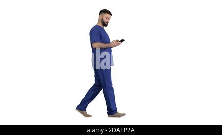 Surgeon doctor walking and using his phone on white background. Stock Photo