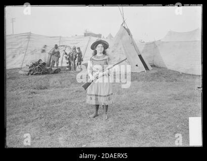 Woman wearing a buckskin dress and holding a rifle at the Madison Street carnival, Chicago, Illinois, September 2, 1904 Stock Photo