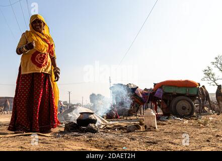 an unidentified woman is making food in earthen chulhas at pushkar camel festival. Stock Photo