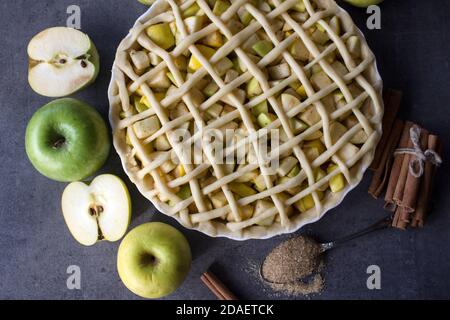 Unbaked apple pie on a table. Cakes decoration ideas.  Gray textured background. Stock Photo