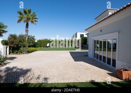 Driveway and front lawn of luxury villa with glass windows in garage door Stock Photo