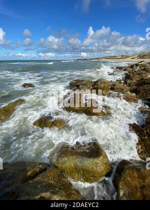 View of Ambleteuse in france over the waves breaking on the rocks Stock Photo