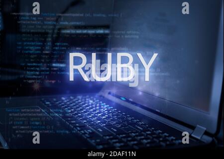 Ruby inscription against laptop and code background. Learn ruby programming language, computer courses, training. Stock Photo