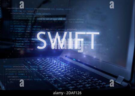 Swift inscription against laptop and code background. Learn swift programming language, computer courses, training. Stock Photo