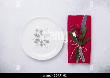 Christmas table setting. White plate, decorative snowflake and silverware on stone background. Top view. Copy space - Image Stock Photo