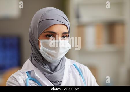 Close-up of muslim female doctor in protective mask looking at camera working at hospital Stock Photo