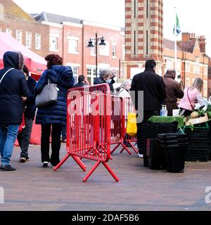 London UK, November 12 2020, Group Of People Or Shoppers Queuing Or Waiting In Line At A Fruit And Vegetable Market Stall Stock Photo