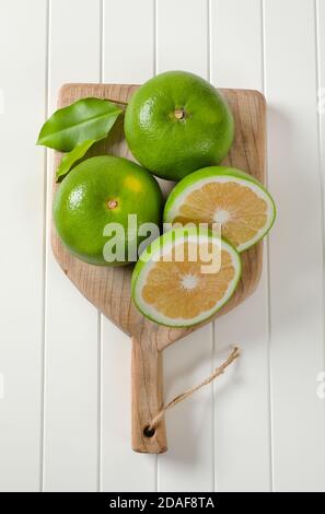 Sweetie fruits (green grapefruits, pomelits) on cutting board Stock Photo