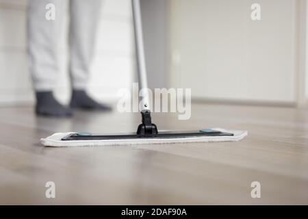 housekeeping concept - close up of modern mop cleaning wooden floor at home Stock Photo
