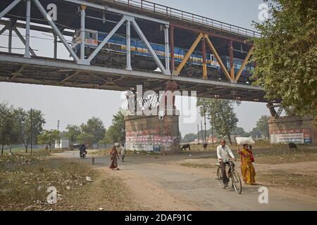 Varanasi, India, December 2015. People passing under a train bridge. Stock Photo