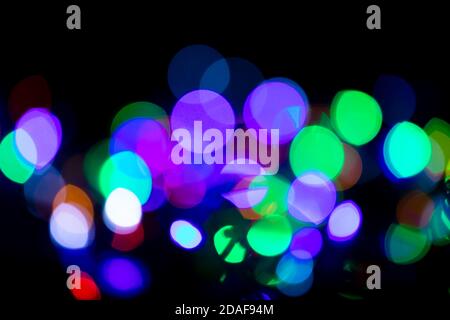 Multicolored spots of light against black background Stock Photo