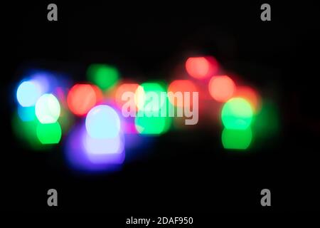 Multicolored spots of light against black background Stock Photo