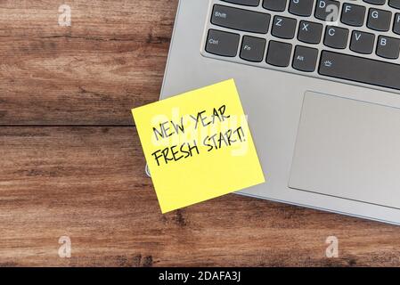 New year fresh start text on yellow adhesive paper note on top of laptop Stock Photo