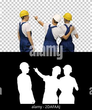 Three male construction workers in hardhats looking at the work Stock Photo