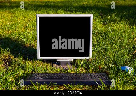 Old Computer Monitor with a Keyboard on the Grass outdoor Stock Photo
