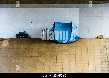 A pop-up tent pitched on Park Square roundabout, Sheffield under a Supertram bridge used by a homeless person sleeping rough Stock Photo