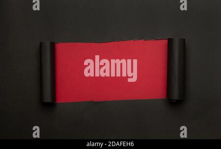 Black torn paper on red background. Black Friday campaign. Stock Photo