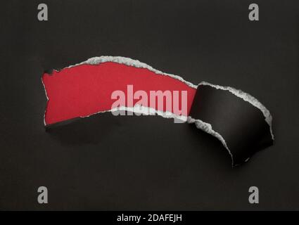 Black torn paper on red background. Black Friday campaign. Stock Photo