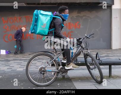 Glasgow, Scotland, UK. 10th November, 2020. UK Weather. A Deliveroo cycle courier taking a break in Sauchiehall Street. Credit: Skully/Alamy Live News Stock Photo