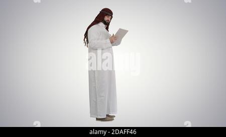 Arabic business man with tablet on gradient background. Stock Photo