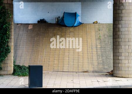 A pop-up tent pitched on Park Square roundabout, Sheffield under a Supertram bridge used by a homeless person sleeping rough Stock Photo