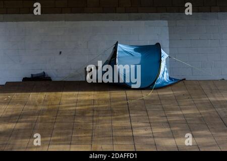 A pop-up tent pitched on Park Square roundabout, Sheffield under a Supertram bridge used by a homeless person sleeping rough Stock Photo