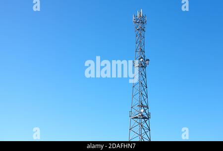 Telecommunication tower of 3G, 4G and 5G cellular network against the blue sky. Stock Photo