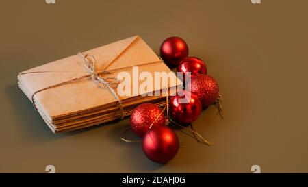 Christmas composition. Craft envelopes and Christmas red balls with copy space. Stack of letters tied with twine Stock Photo