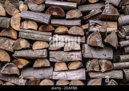 Background of splitted, dried and stacked firewood. Bunch of wood. Stock Photo