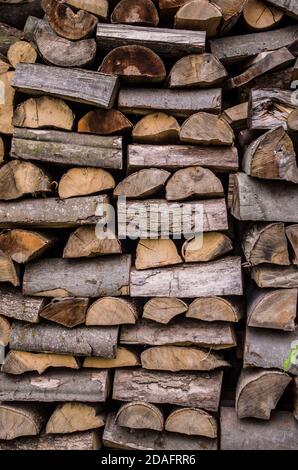 Background of splitted, dried and stacked firewood. Bunch of wood. Stock Photo