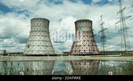 View of the power plant and cooling towers. The smoke goes out from a cooling tower of an operating power station. Cooling towers of a thermoelectric Stock Photo