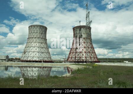 View of the power plant and cooling towers. The smoke goes out from a cooling tower of an operating power station. Cooling towers of a thermoelectric Stock Photo