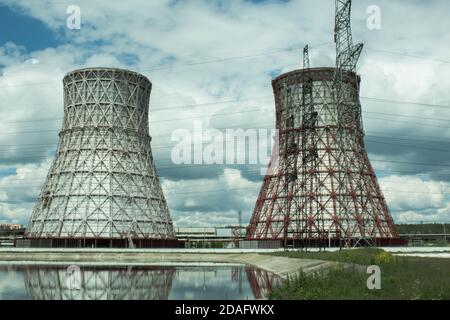 View of the power plant and cooling towers. The smoke goes out from a cooling tower of an operating power station. Cooling towers of a thermoelectric Stock Photo