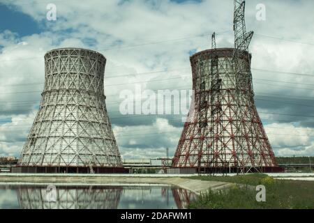 View of the power plant and cooling towers. The smoke goes out from a cooling tower of an operating power station. Cooling towers of a thermoelectric Stock Photo