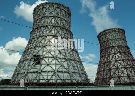 View of the power plant and cooling towers. The smoke goes out from a cooling tower of an operating power station. Cooling towers of a thermoelectric Stock Photo