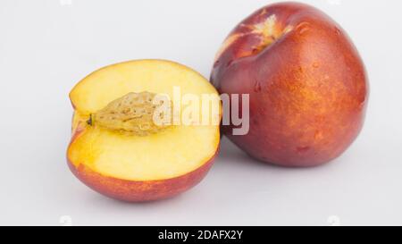 Fresh juicy peaches on a white plate. Close-up Fresh organic peaches nectarine on a white plate. Stock Photo