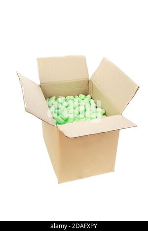 Vertical shot of a cardboard box with green packing styrofoam peanuts Stock Photo