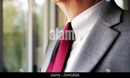 close up of man neck in a grey business suit and red tie, selective focus with copy space background. Stock Photo