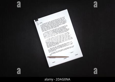 Picture of thick contract with dummy text and ball point pen to sign it. Stock Photo