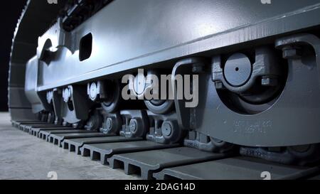 continuous tracks of construction caterpillar, bulldozer steel metal wheels close up. Stock Photo