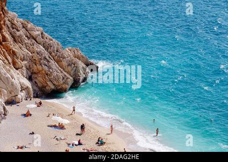 View of the turquoise beach. Beautiful Kaputas Beach (Turkey) with people resting under the sun and in the sea Stock Photo