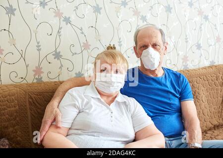 elderly couple in medical masks, self-isolation mode for the elderly during the epidemic Stock Photo
