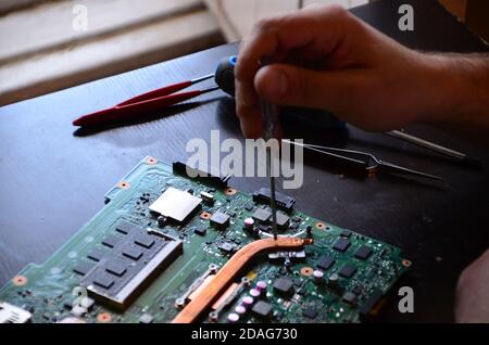 The man hand of the technician assembling inside of tablet by screwdriver in the lab. the concept of computer hardware, mobile phone, electronic Stock Photo