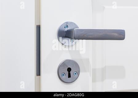 Closeup of metal doorhandle on wooden door. Stock Photo