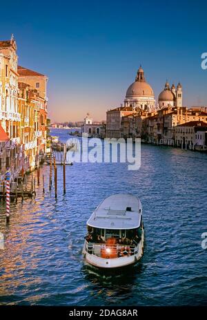 Grand Canal with Vaporetto waterbus and the dome of Basilica di Santa Maria della Salute behind Venice Italy Stock Photo