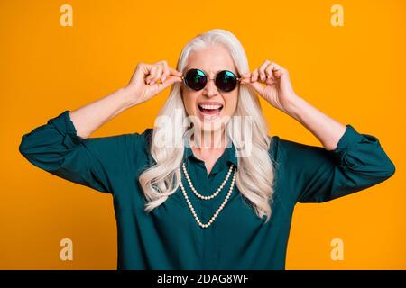 Photo of pretty cheerful white haired grandma lady music lover senior party active way of life cool look wear green shirt sun specs necklace isolated Stock Photo