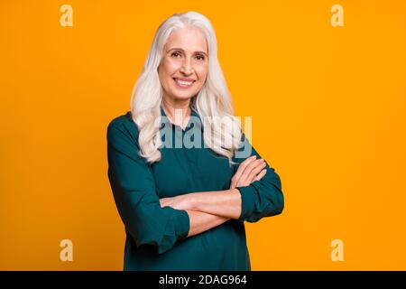 Photo of pretty confident white haired grandma lady holding hands crossed responsible chief company ceo founder wear green shirt isolated bright Stock Photo