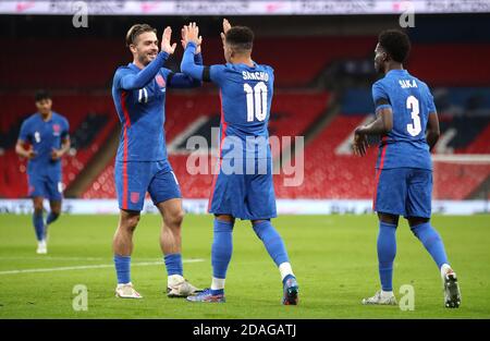 England's Jadon Sancho (centre right) celebrates scoring his side's second goal of the game with Jack Grealish during the international friendly at Wembley Stadium, London. Stock Photo